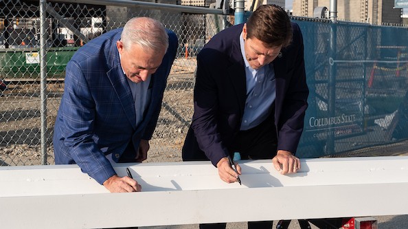 OhioHealth President and Chief Executive Officer Stephen Markovich and Columbus State President David Harrison sign the OhioHealth Hall beam on March 31.