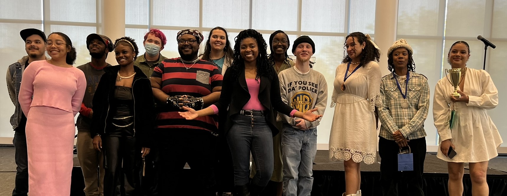Poet Barbara Fant is in the middle with a pink shirt and black jacket surrounded by Columbus State students who took part in the Poetry Month Slam. 