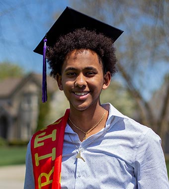Smiling student in graduation cap.