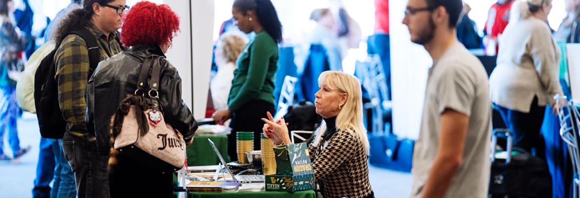 University representative talks to students at a transfer fair