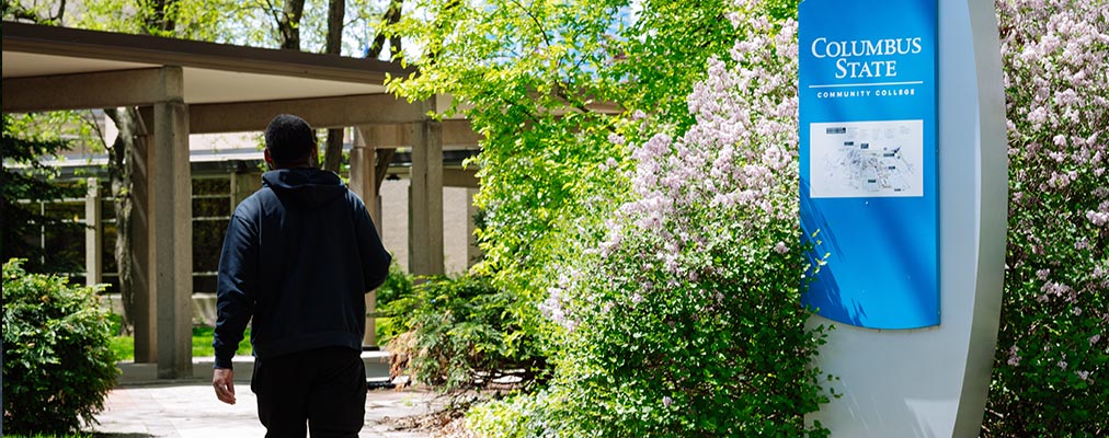 Student walking on campus during sunny day