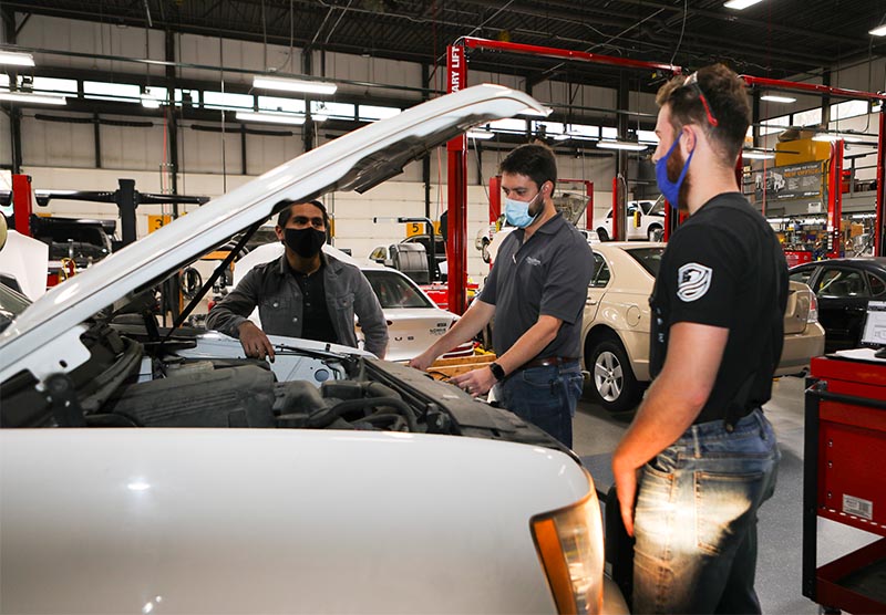 Left to right: Jose Nunez, student; Ian Andrews, assistant professor; and Luke Eckels, student, during the Powertrain Systems Service class in the Automotive Technology Lab on November 19 .