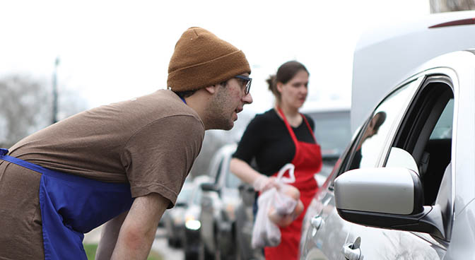 
David Wilson talks to motorist during the Market drive-up curbside service hours on March 28.
